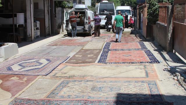 Tozla mücadelede çaresiz kalan mahalleli yola halı serdi